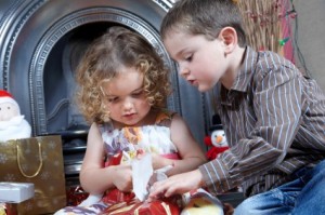 Brother helping his Little Sister Opening Her Xmas Presents