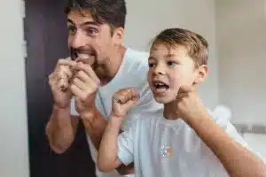 Dental Health - son and dad flossing teeth together