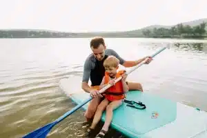 son and dad paddleboarding on father's day